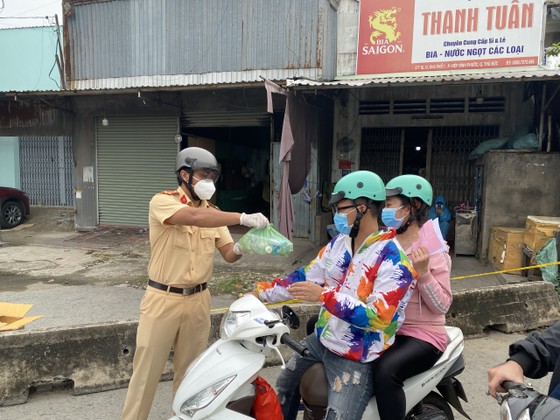 CSGT TPHCM hỗ trợ nước, sữa, khẩu trang... cho người dân trên đường về miền Tây  ảnh 2