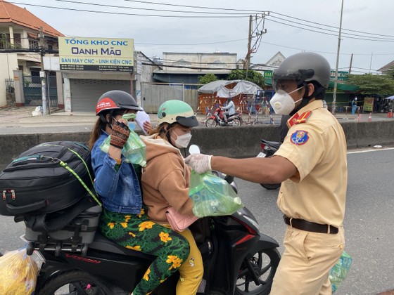 CSGT TPHCM hỗ trợ nước, sữa, khẩu trang... cho người dân trên đường về miền Tây  ảnh 5