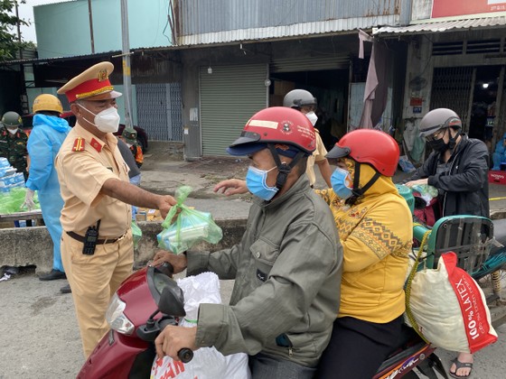 CSGT TPHCM hỗ trợ nước, sữa, khẩu trang... cho người dân trên đường về miền Tây  ảnh 6