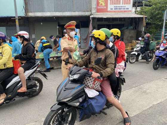 CSGT TPHCM hỗ trợ nước, sữa, khẩu trang... cho người dân trên đường về miền Tây  ảnh 4