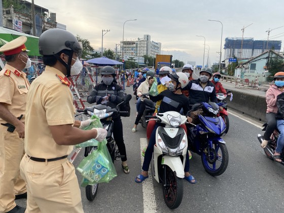 CSGT TPHCM hỗ trợ nước, sữa, khẩu trang... cho người dân trên đường về miền Tây  ảnh 1